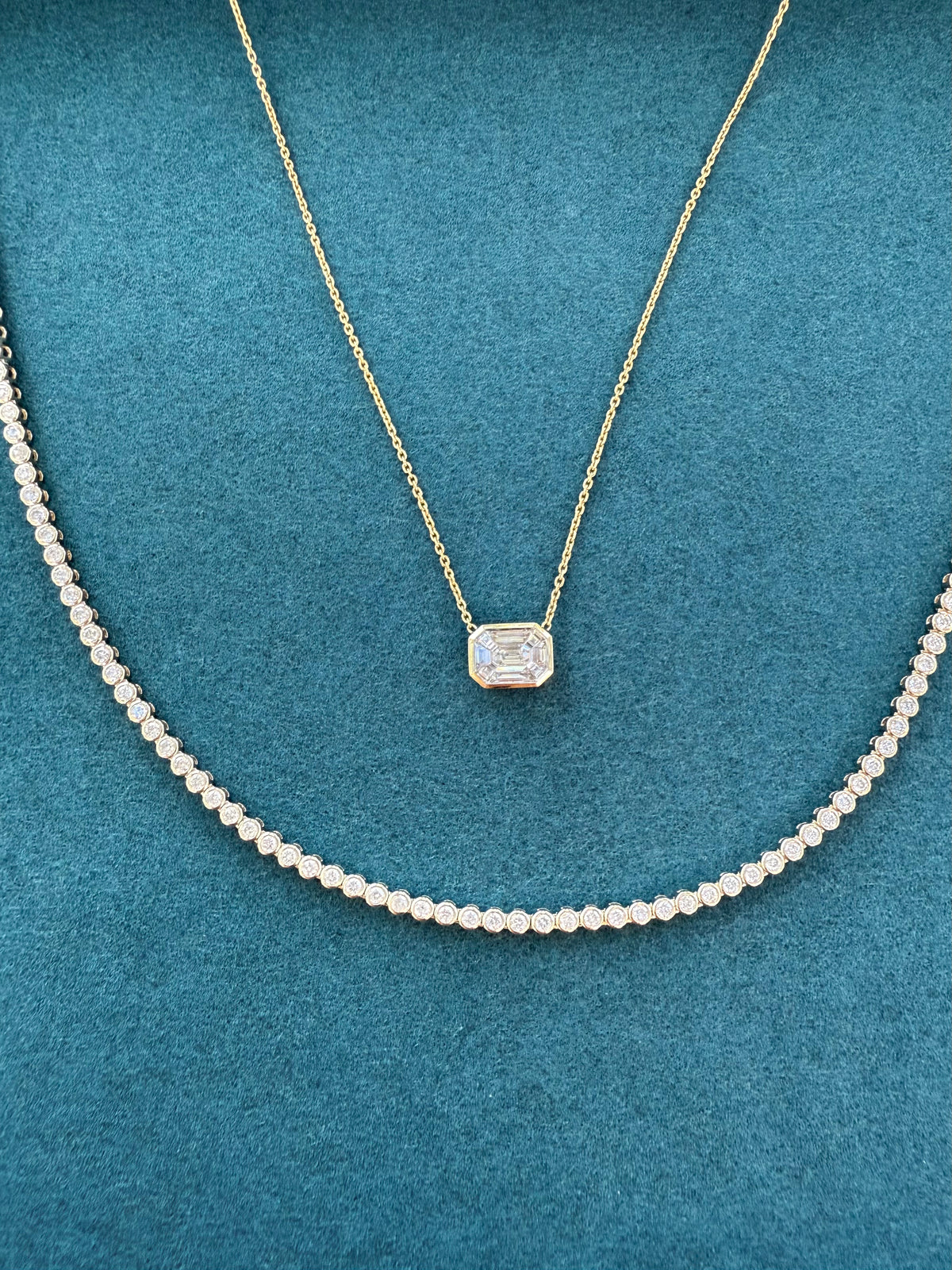 Gold necklace with a diamond pendant on a teal background