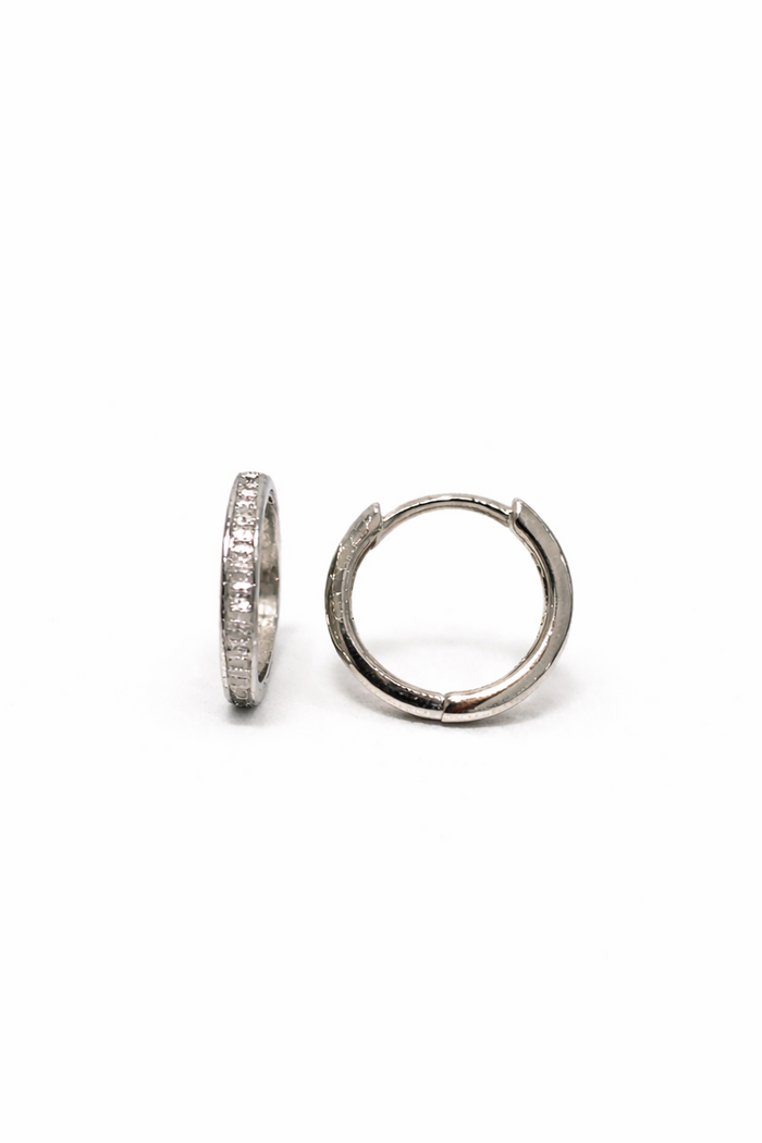 Pair of white gold and baguette diamond hoop earrings on a white background