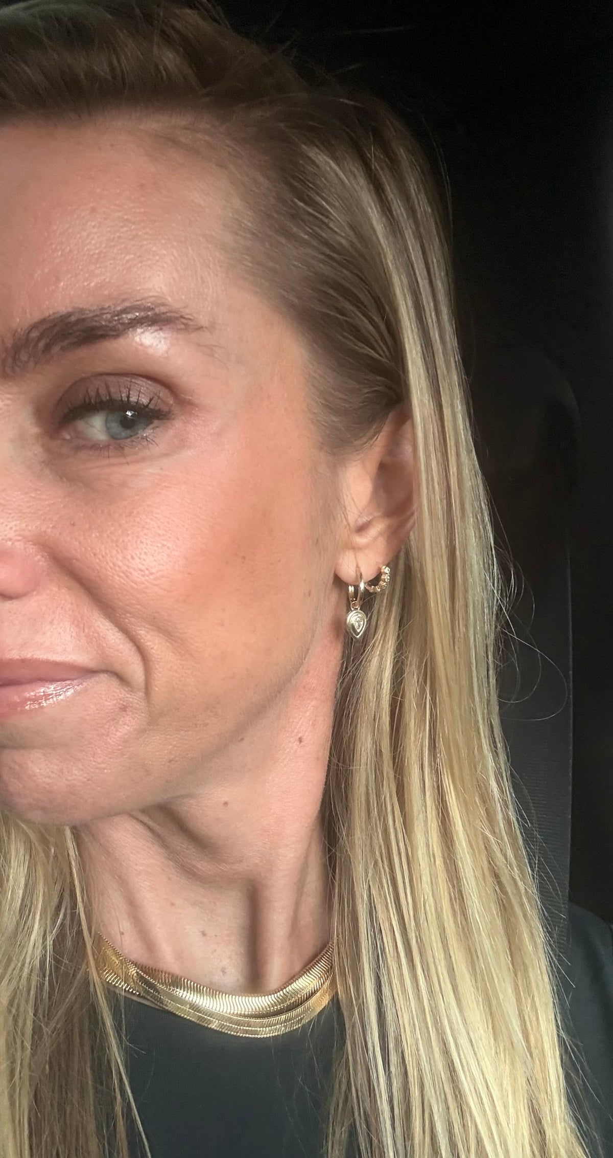 Close-up of a person with blonde hair wearing earrings.