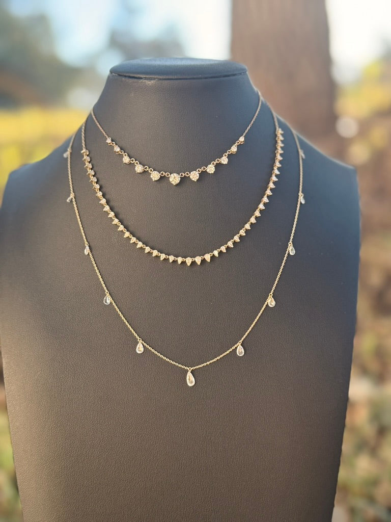 black necklace display with 3 diamond necklaces