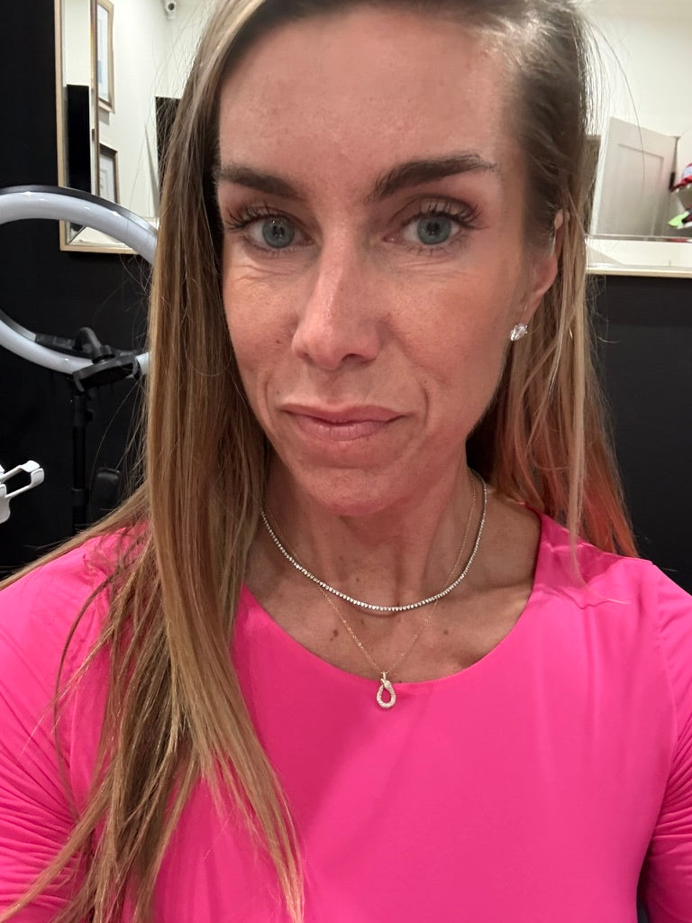 woman with pink shirt and 2 necklaces 
