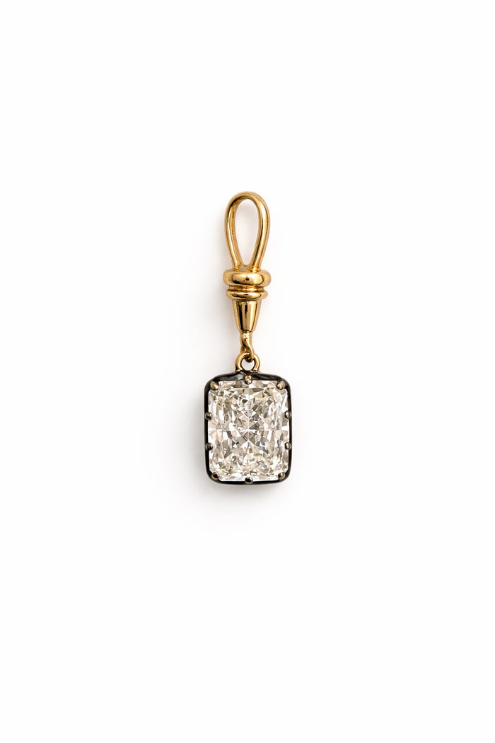 Gold pendant with a radiant diamond on a white background