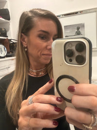 Person holding a phone with a visible brand logo in an indoor setting