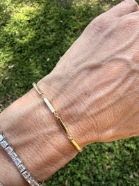 Gold bracelet on a wrist with a natural background