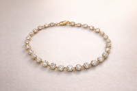 Gold bracelet with diamonds on a light pink background