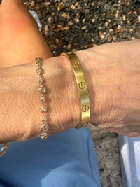Gold bracelet on a wrist with a blurred background
