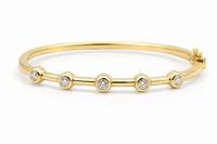 Gold bracelet with small diamonds on a white background