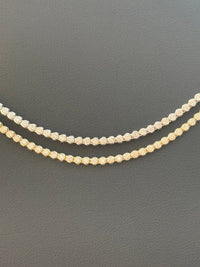 Two diamond necklaces on a dark gray background