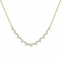 A delicate yellow gold chain necklace featuring a curved row of small, clear triangular gemstones in prong settings, displayed against a solid white background.