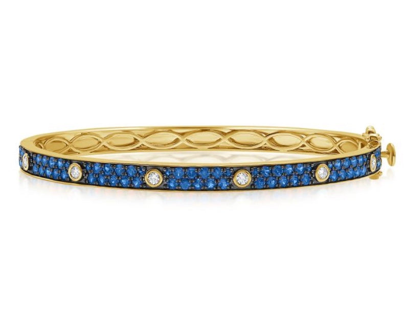 The Karat Concierge Pave Muse yellow gold bangle featuring blue gemstone pavé and bezel-set diamonds.