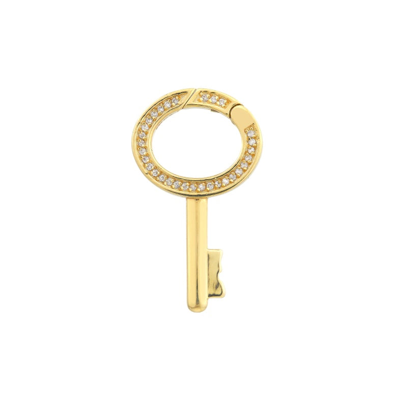Gold key-shaped earring with gemstones on a white background