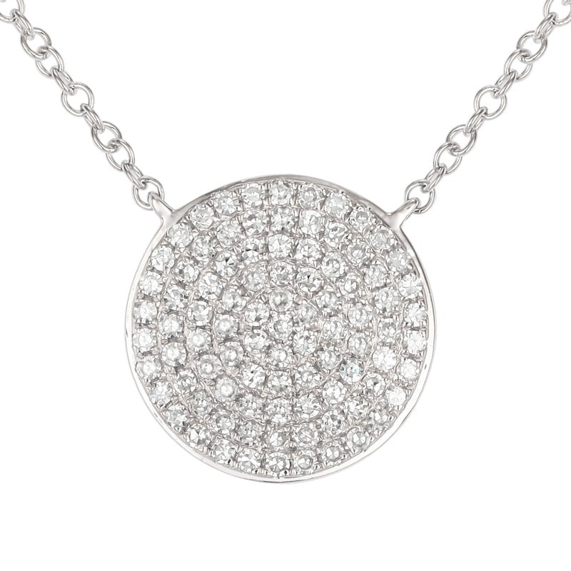 Silver necklace with a round, diamond-studded pendant on a white background