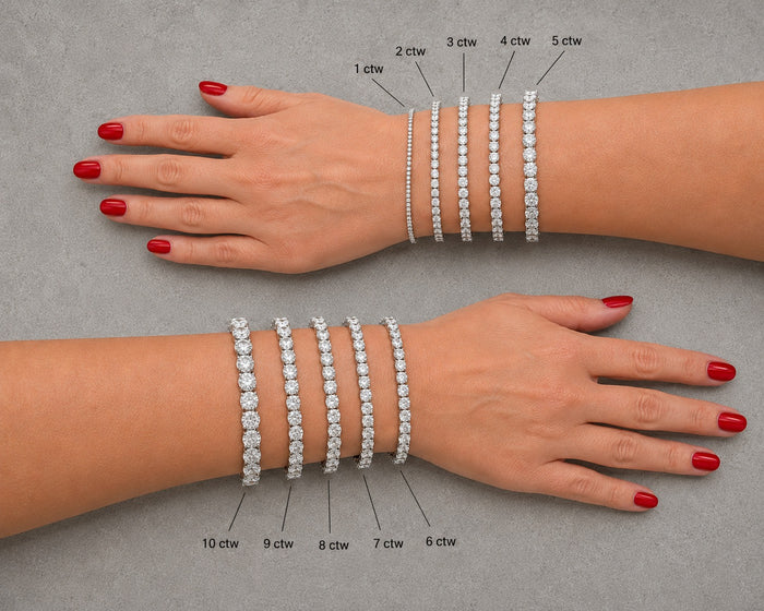 Two hands wearing diamond bracelets with weight labels on a gray background