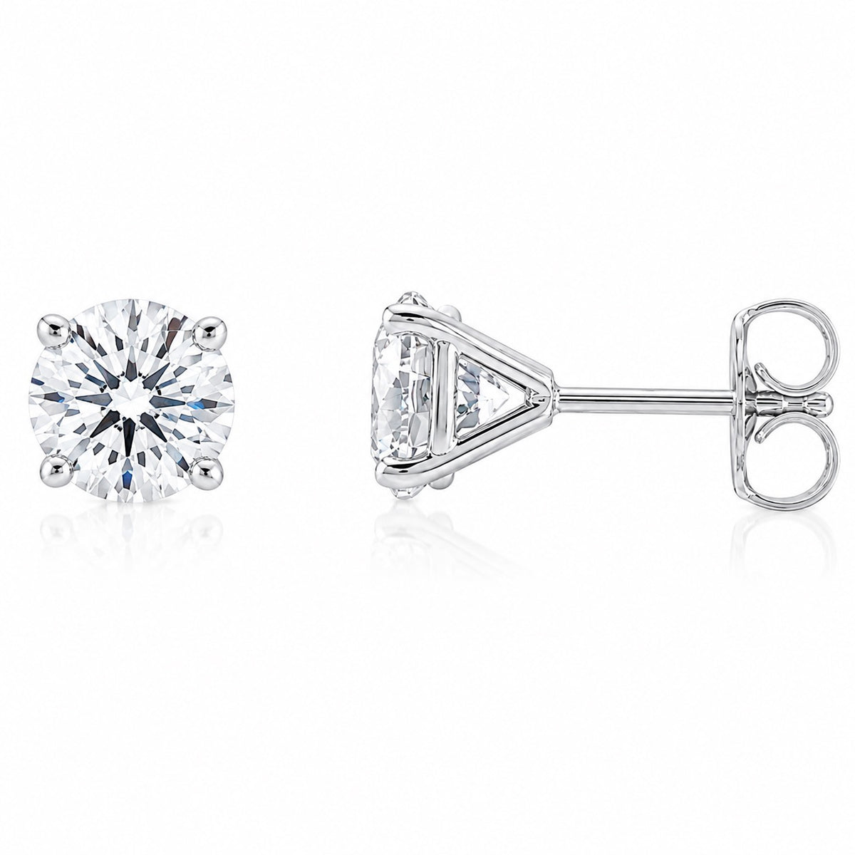 A pair of silver stud earrings, one shown from the front displaying a round brilliant-cut clear gemstone and the other from the side displaying the triangular prong setting and post with butterfly back, on a white background with a soft reflection.