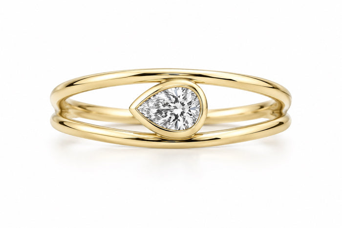 yellow gold ring with a bezel set pear shaped diamond