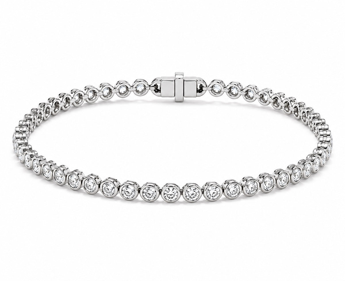 A white gold tennis bracelet featuring round diamond in a classic bezel set design, displayed on a clean white background.