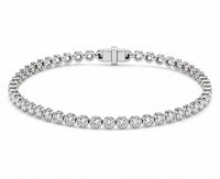 A white gold tennis bracelet featuring round diamond in a classic bezel set design, displayed on a clean white background.