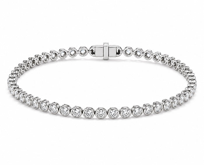 A white gold tennis bracelet featuring round diamond in a classic bezel set design, displayed on a clean white background.