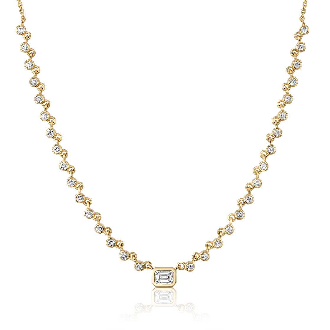 The Karat Concierge Peyton bezel set necklace in 14K yellow gold with emerald cut and round brilliant diamonds.
