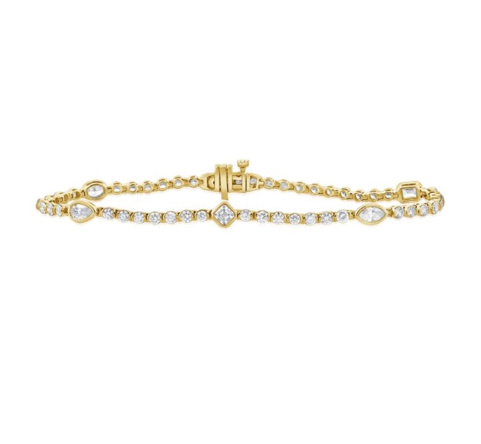 The Karat Concierge Kate bezel set tennis bracelet in yellow gold with mixed shape diamonds and a secure clasp.