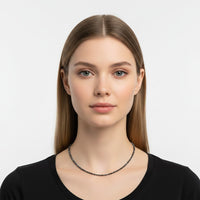 The Karat Concierge black diamond beaded necklace with 18K yellow gold extender worn by a model in a black top.