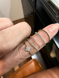 The Karat Concierge black diamond eternity band in 14K yellow gold with black rhodium worn on a finger with stack rings