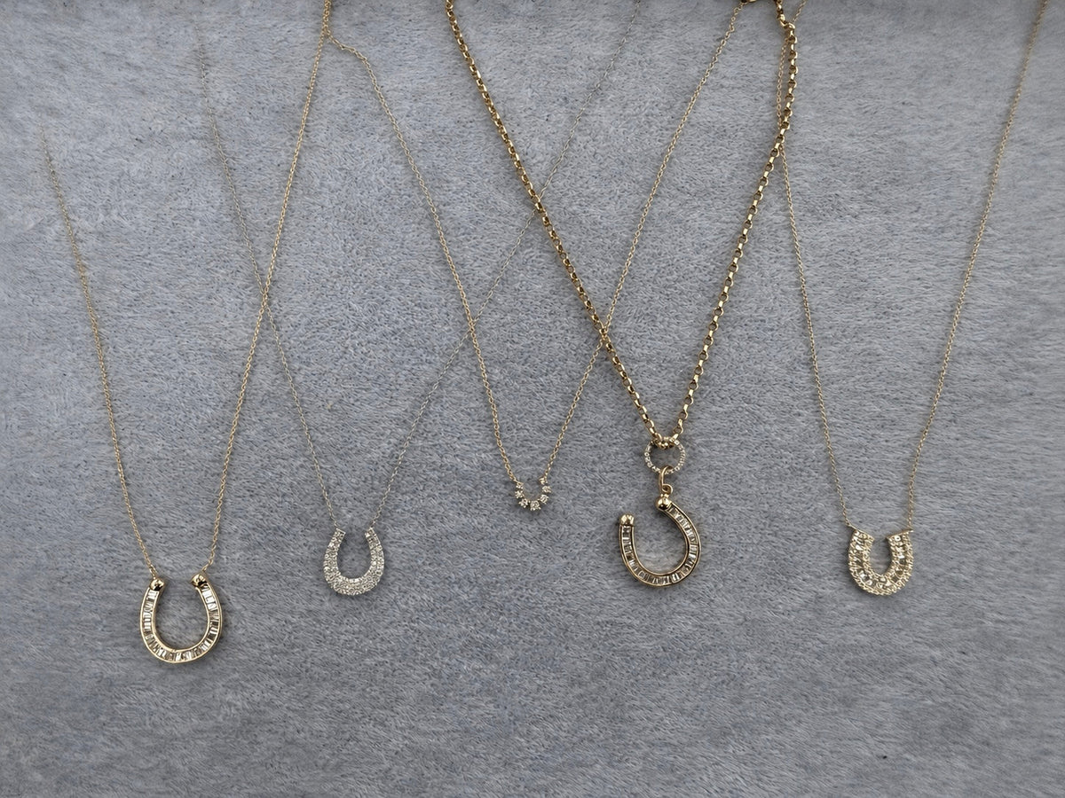 The Karat Concierge collection of gold horseshoe necklaces featuring graduated diamonds on delicate chains