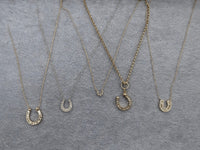 The Karat Concierge collection of gold horseshoe necklaces featuring graduated diamonds on delicate chains