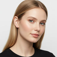 The Karat Concierge horseshoe stud earrings with natural diamonds worn by a blonde model against a white background.