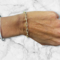 The Karat Concierge diamond link bangle in 14K gold worn on a wrist against a white marble background.