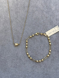 The Karat Concierge 14K yellow gold paperclip bracelet with 19 diamonds and a matching delicate gold pendant necklace.