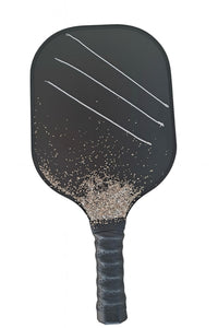 The Karat Concierge diamond tennis bracelets displayed on a black pickleball paddle with decorative stone accents.