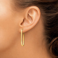 The Karat Concierge elongated paperclip earrings in 14K yellow gold worn on a model ear
