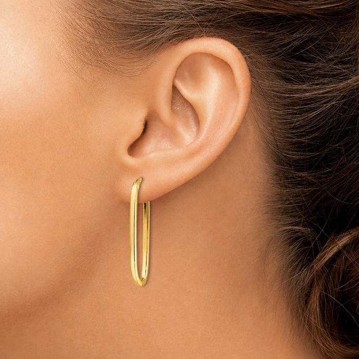 The Karat Concierge elongated paperclip earrings in 14K yellow gold worn on a model ear