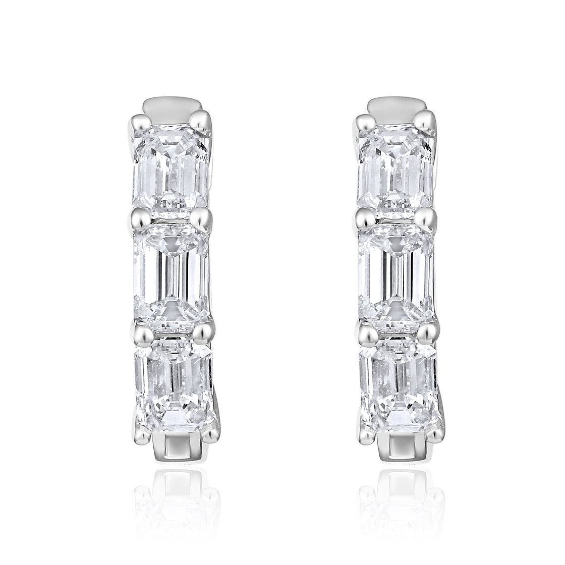The Karat Concierge 14K white gold huggie earrings featuring three emerald cut diamonds each with a polished finish.