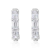 The Karat Concierge 14K white gold huggie earrings featuring three emerald cut diamonds each with a polished finish.