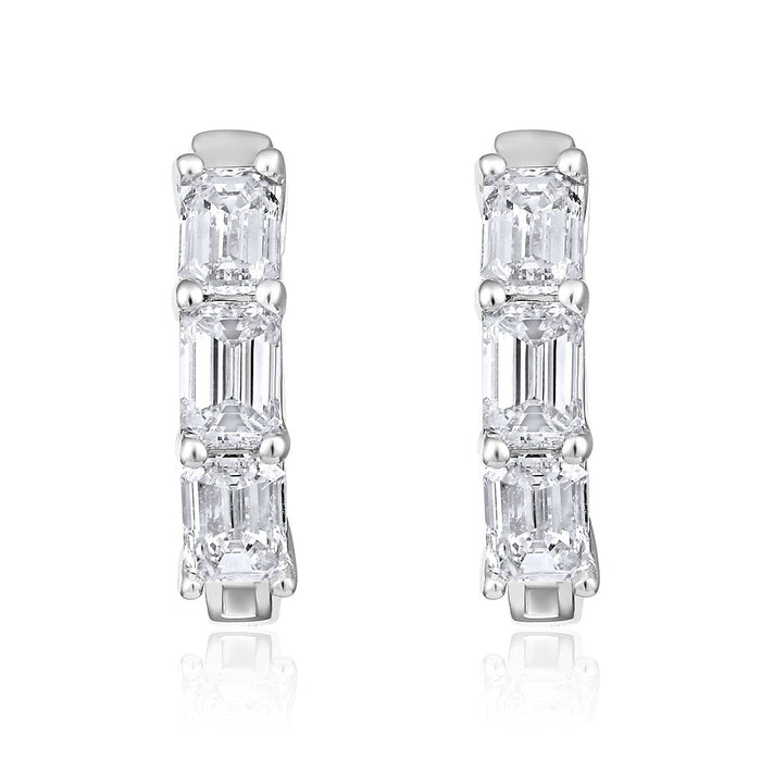 The Karat Concierge 14K white gold huggie earrings featuring three emerald cut diamonds each with a polished finish.