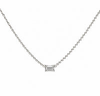 The Karat Concierge emerald cut solitaire diamond necklace on a delicate 14K yellow gold chain.