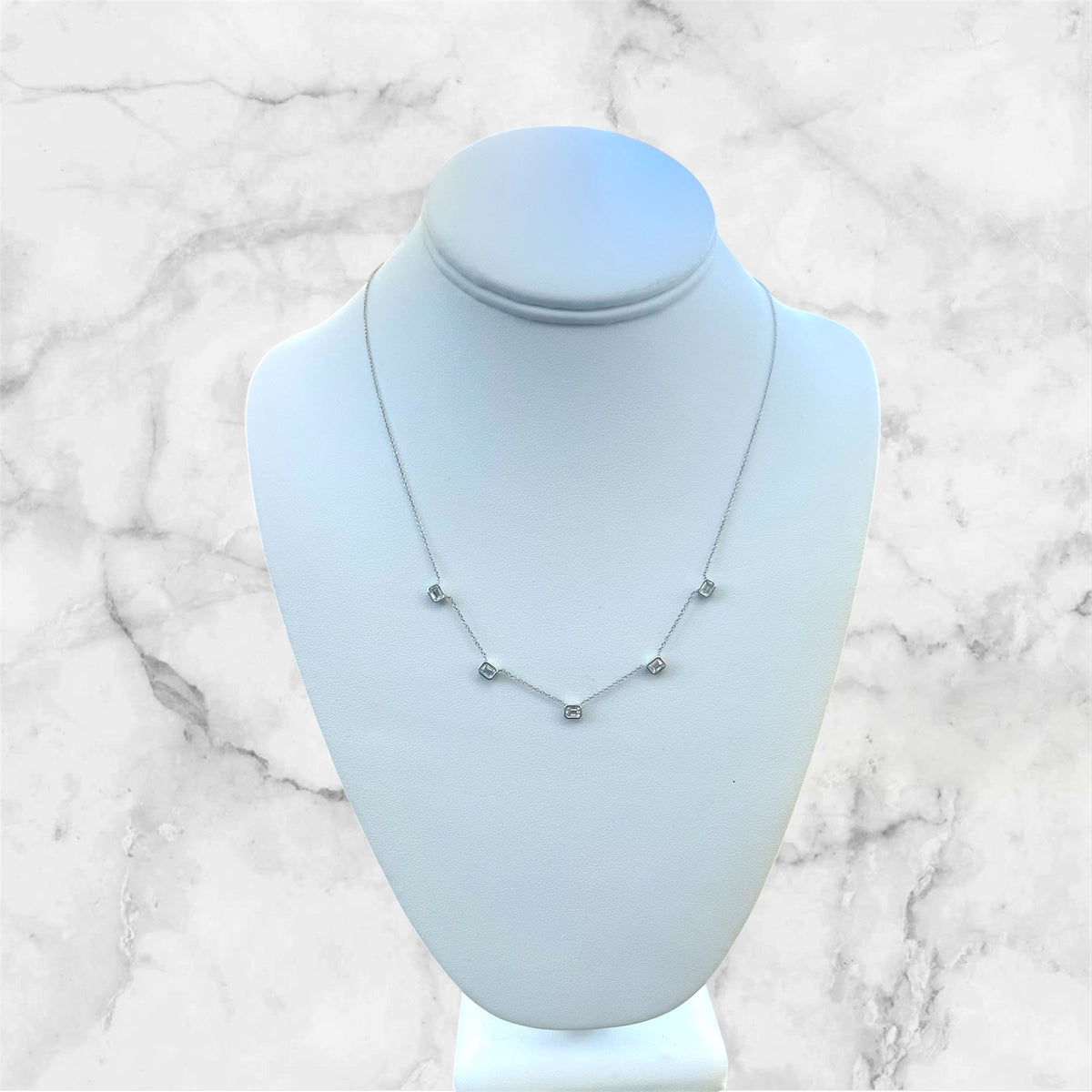 The Karat Concierge 14K white gold necklace with five bezel-set emerald-cut lab-grown diamonds on a display bust.