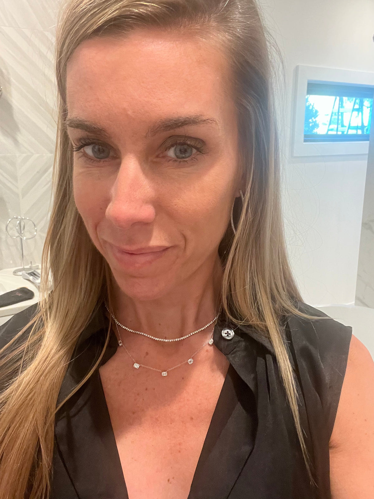 The Karat Concierge 14K gold necklace featuring five bezel-set emerald cut lab grown diamonds worn by a woman.