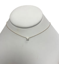 The Karat Concierge emerald cut solitaire diamond necklace on a delicate 14K yellow gold chain.