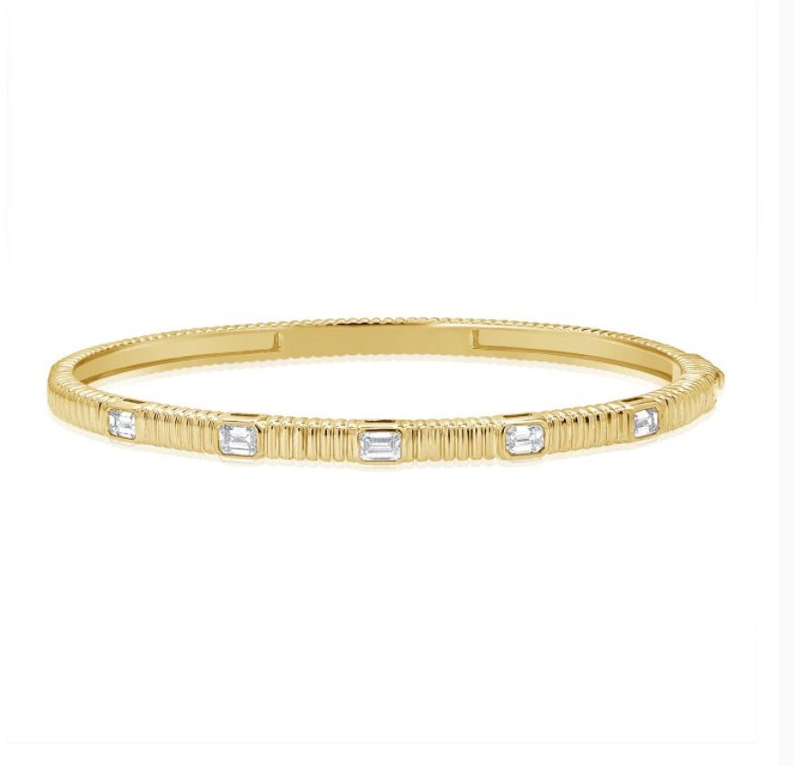 The Karat Concierge fluted gold bangle featuring five bezel-set emerald cut diamonds with a secure double latch.