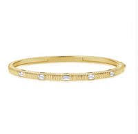 The Karat Concierge fluted gold bangle featuring five bezel-set emerald cut diamonds with a secure double latch.