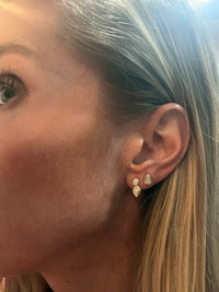 The Karat Concierge Gatsby Stud emerald diamond earrings in 14K yellow gold worn on a woman's earlobe