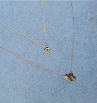 The Karat Concierge 14K yellow gold Chai necklace with pavé diamonds on a delicate chain against a blue background.