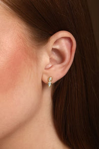 The Karat Concierge Gatsby drop earrings featuring a round and pear-shaped diamond in 14K gold worn on an earlobe.