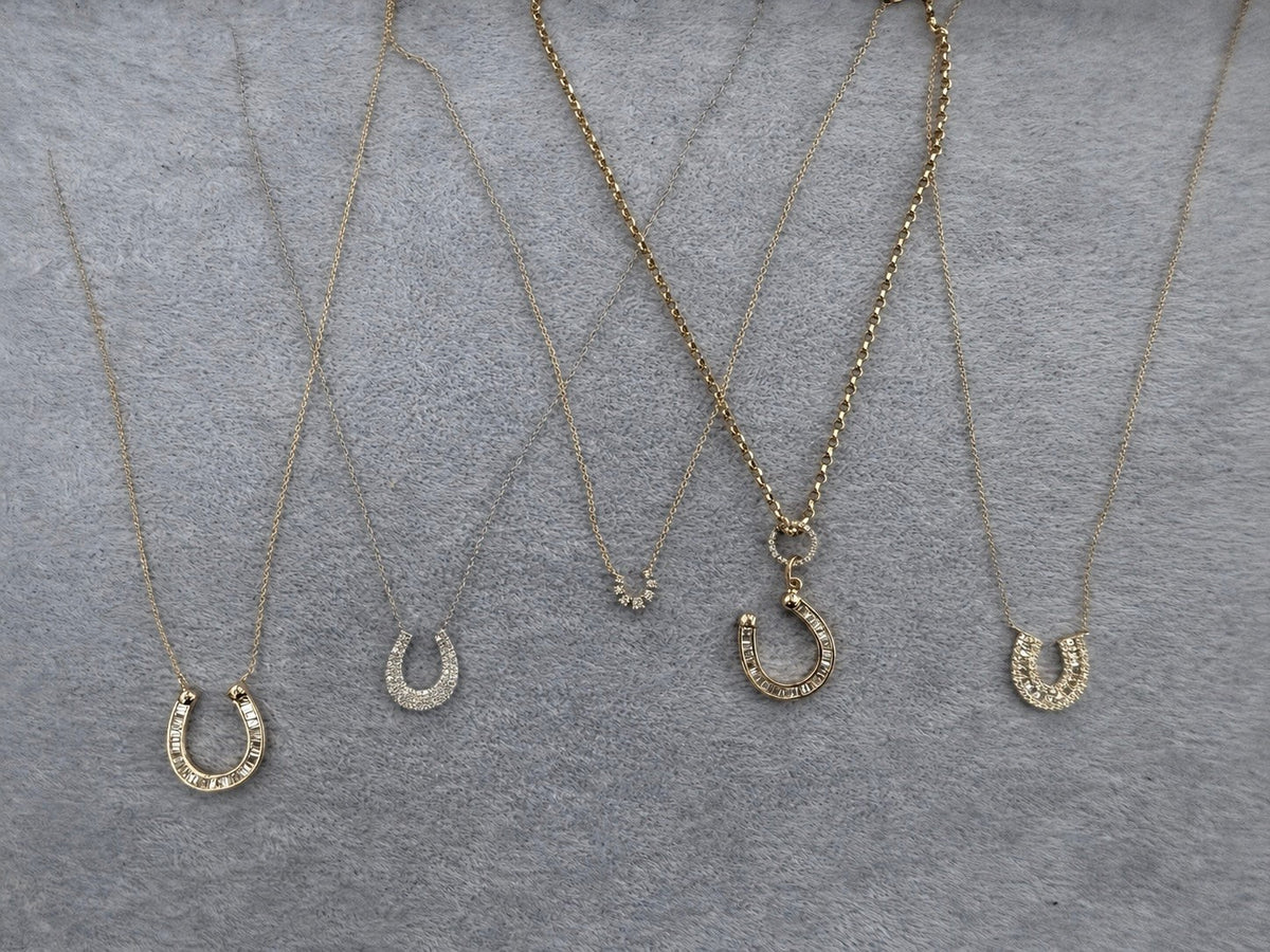 The Karat Concierge Fortuna Pave Horseshoe Necklace collection featuring various 14K yellow gold diamond pendants.