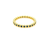 The Karat Concierge 14K yellow gold eternity band featuring a continuous row of bezel-set blue sapphires.