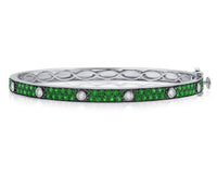 The Karat Concierge Pave Muse bangle in white gold with green gemstones and bezel-set diamonds.