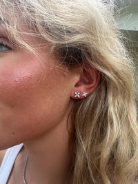 The Karat Concierge Hannah star stud earrings in 14K yellow gold with natural diamonds worn on a woman's earlobe.